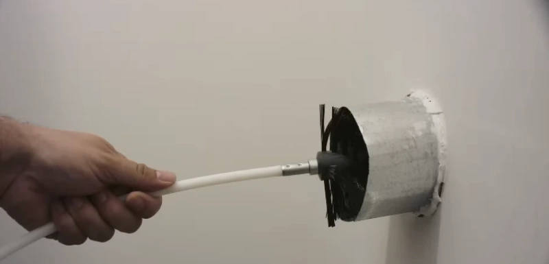 Technician inserting a rotary brush into a dryer vent during cleaning service in St. Augustine, FL